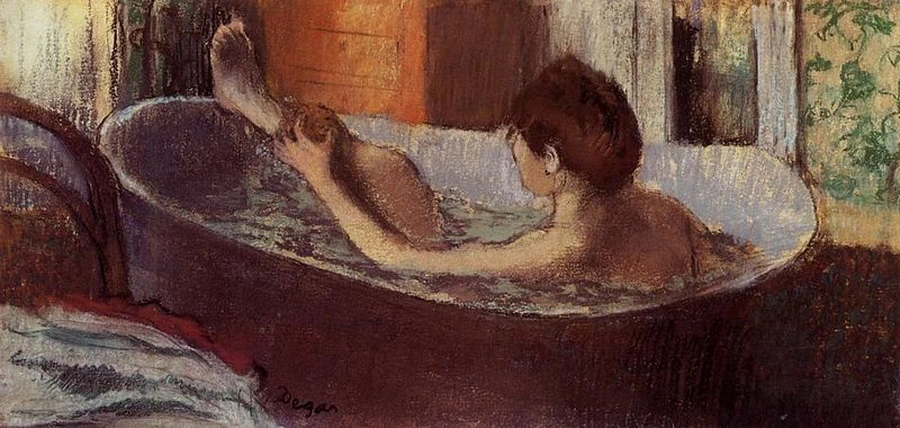 Donna nel suo bagno che si spugna la gamba